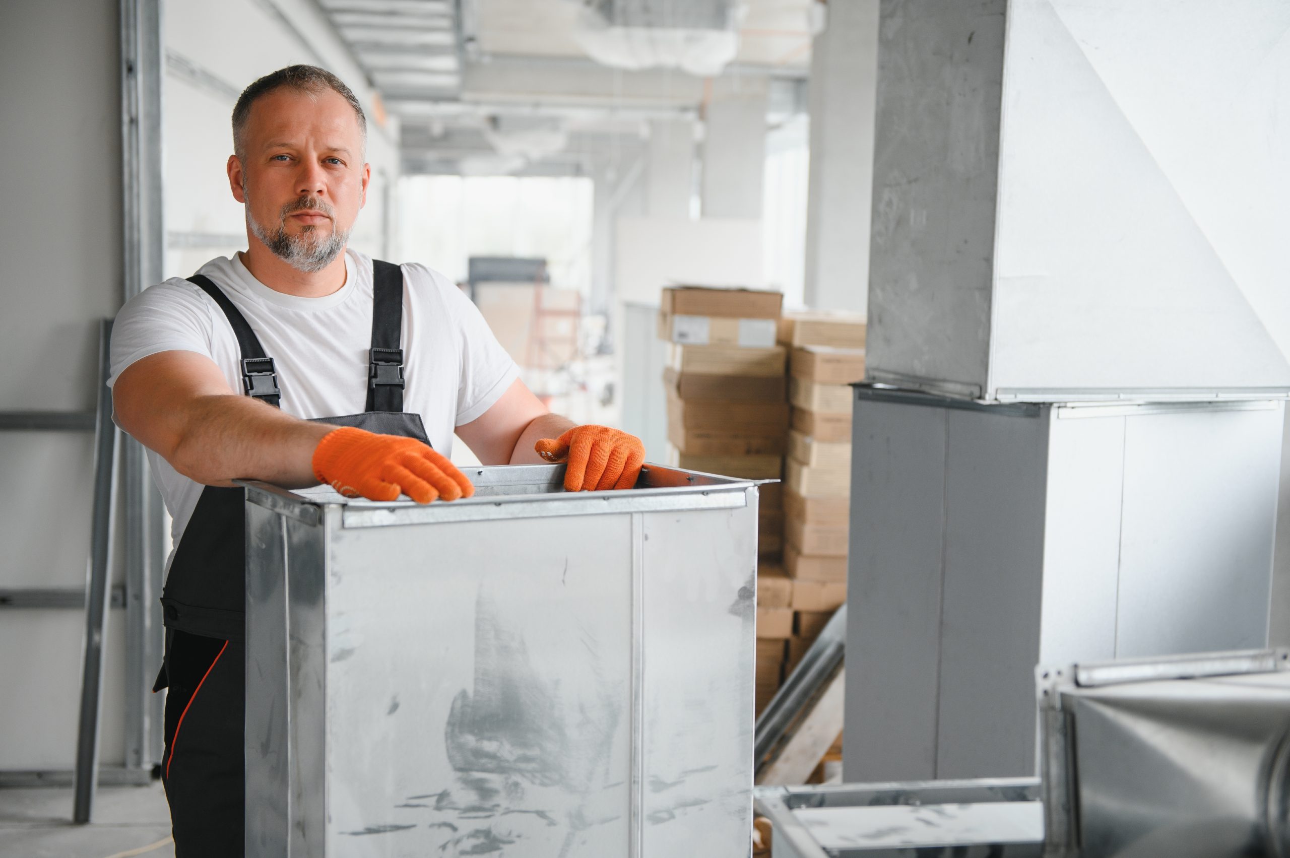 hvac services - worker install ducted pipe system for ventilation and air conditioning in office.