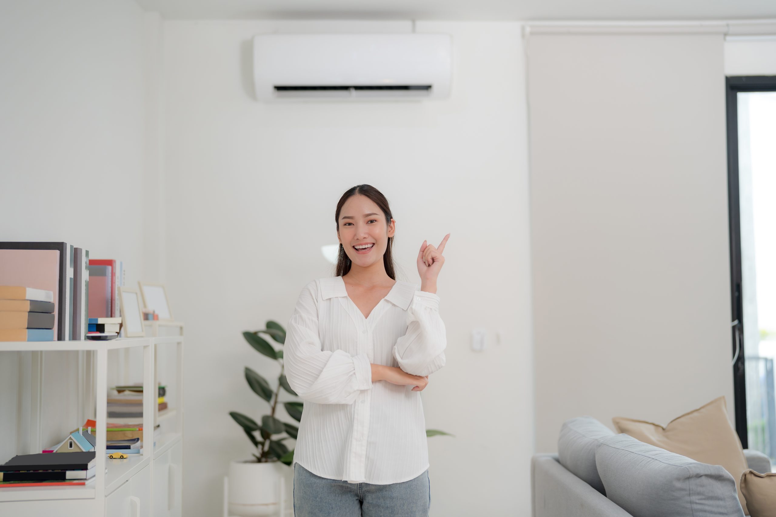 Smiling young woman with pointing gesture indoors
